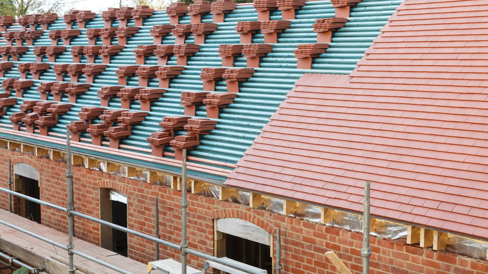 Full re-roof in progress with new battens, breathable membrane and stacks of clay tiles part-laid, Oxfordshire